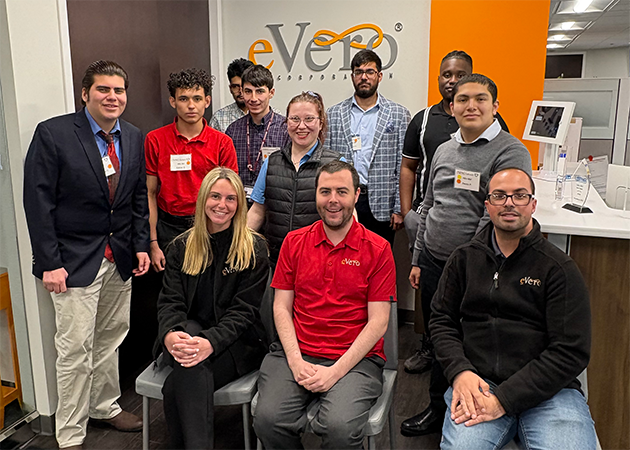 Guests posing in from of the eVero sign